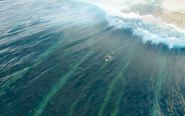 Surfer paddling out to catch the big wave